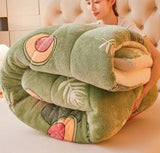 Folded plush toy shaped like a caterpillar held by a person on a light background