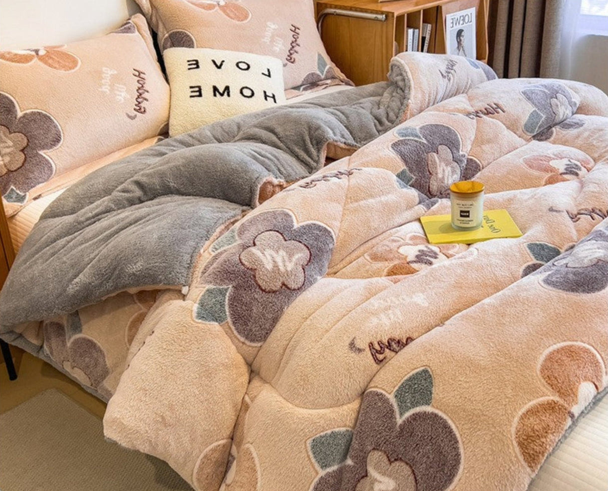 Floral patterned comforter set on a bed with pillows and a cup on a nightstand.