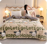 Woman sitting on a bed with a cartoon-themed comforter in a bedroom setting.