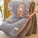Fluffy blanket with cartoon bear design held by a person in a home setting.