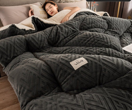 Person lying under a weighted blanket with a visible brand label, in a cozy bedroom setting.