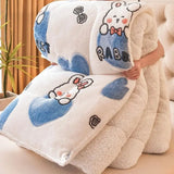 Fluffy blanket with cartoon rabbit design held by a person indoors.