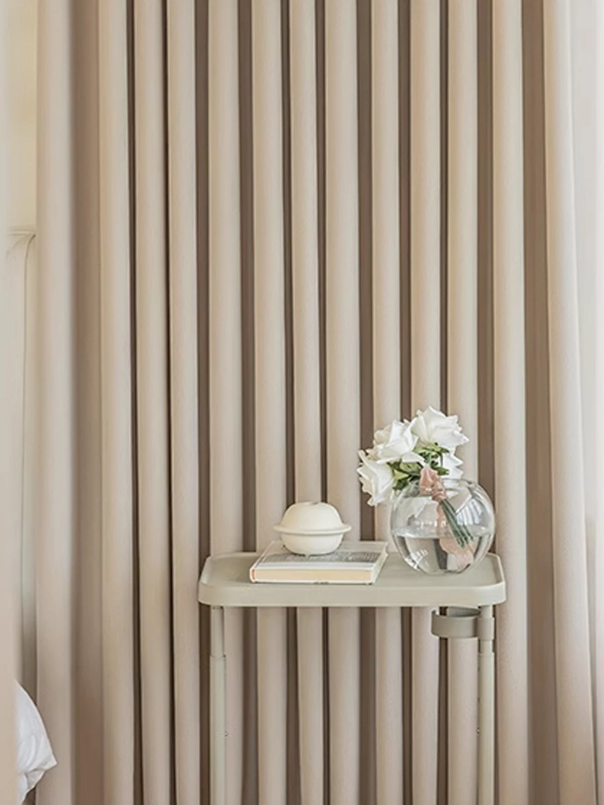 Beige striped wallpaper with a small table and decorative items against it