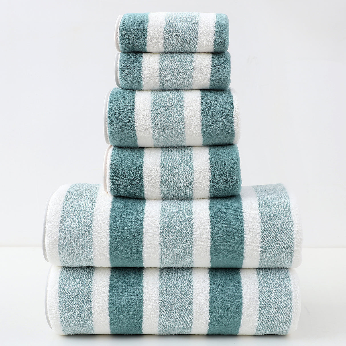 Stack of blue and white striped towels on a light gray background