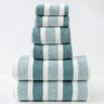 Stack of blue and white striped towels on a light gray background