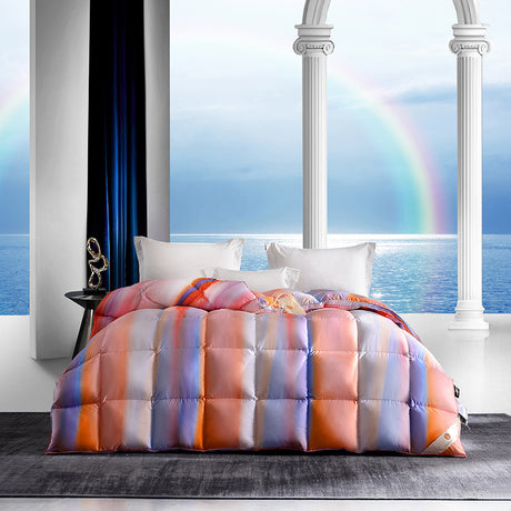 Colorful striped comforter on a bed with a window view of water and a rainbow.