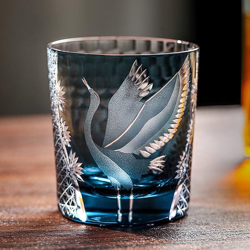 Decorative glass with bird etching on a wooden surface