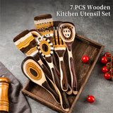 7-piece wooden kitchen utensil set on a tray with tomatoes and a towel in the background.