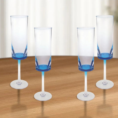 Four champagne flutes with blue accents on a wooden table