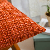 Close-up of an orange textured pillow with a blurred indoor background