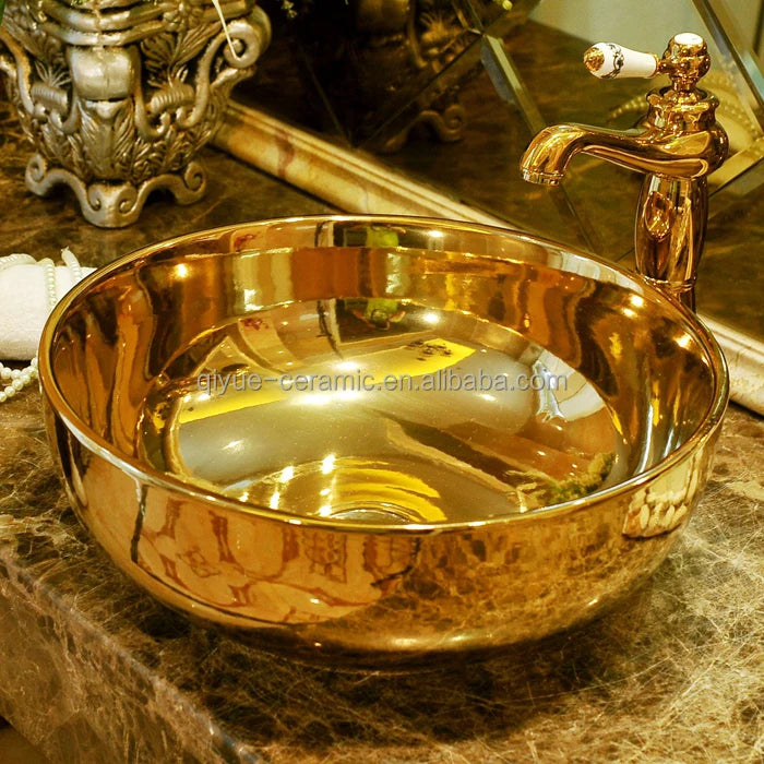 Gold ceramic sink with faucet on a marble surface