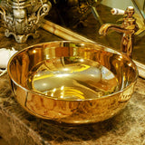 Gold ceramic sink with faucet on a marble surface