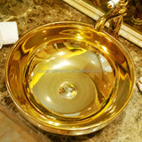 Gold ceramic bowl with handles on a marble surface
